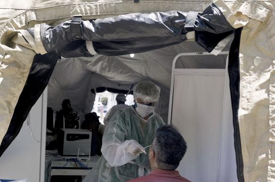 Una enfermera realiza una prueba de hisopo en un paciente como parte de las nuevas medidas del gobierno de Río de Janeiro