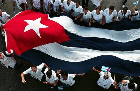 Estudiantes cubanos portan la bandera nacional. (foto: ANSA)