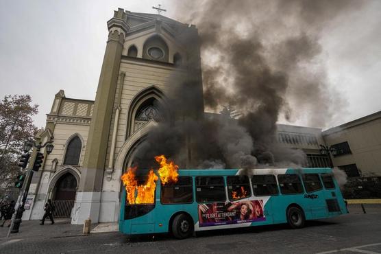 Un autobús está en llamas frente a una iglesia durante una protesta estudiantil en Santiago ayer