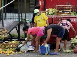Personas recogen frutas y verduras desechadas por vendedores ambulantes en Belem, estado de Pará