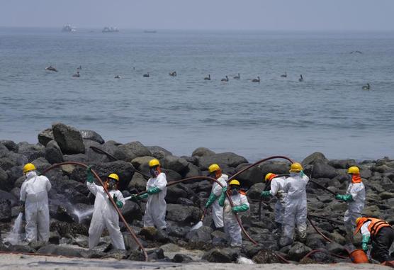 Equipos de limpieza trabajan en la playa de Pocitos contaminada por un derrame de petróleo en Ancón, Perú