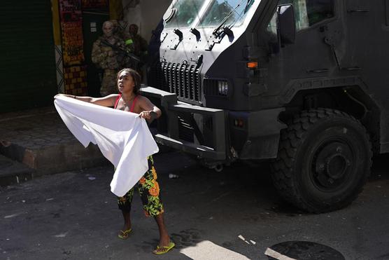 Una residente agita una sábana blanca para pedir paz después de una operación policial que resultó en casi 20 muertes