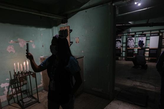 Una enfermera camina frente a imágenes de personas que fueron torturadas y asesinadas durante la dictadura chilena