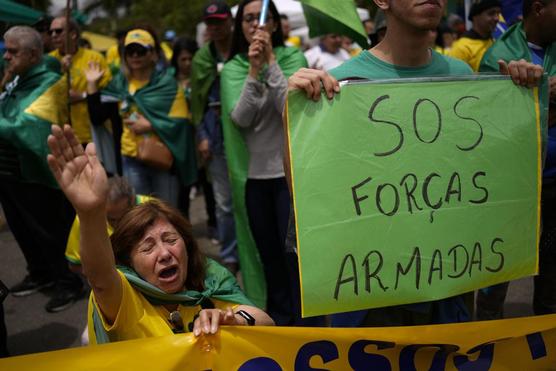 Militante de Bolsonaro reza durante una protesta contra la derrota del mandatario en la segunda vuelta de las elecciones 