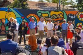 Los artistas Mon Laferte (3d) y Alejandro "Mono" González (c) posan junto a otras personas durante la inauguración de su mural