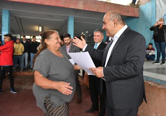 Una vecina recibe la escritura de manos del mandatario