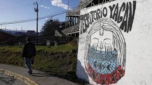 Un hombre camina frente a un mural de la comunidad Yagán, en Puerto Williiams EFE