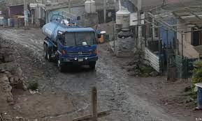 Un camión de reparto de agua pasa por las casas en el distrito de Pamplona Alta, en Lima