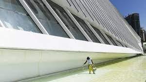 Un trabajador limpia la piscina exterior del Museo del Mañana de Río - AFP