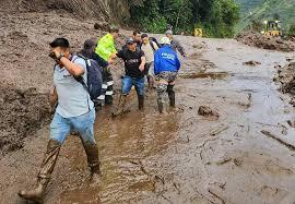 La policía ecuatoriana ayudan a los civiles a evacuar el lugar de un deslizamiento de tierra en Baños - AFP