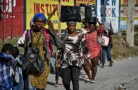 Mujeres caminan por una vía con sus pertenencias, en Puerto Príncipe (Haití), en una fotografía de archivo. EFE/ Siffroy Clarens